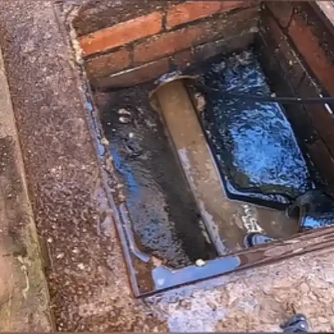 Floor drain after cleaning Brick-lined floor drain after cleaning with a water hose line in the drain